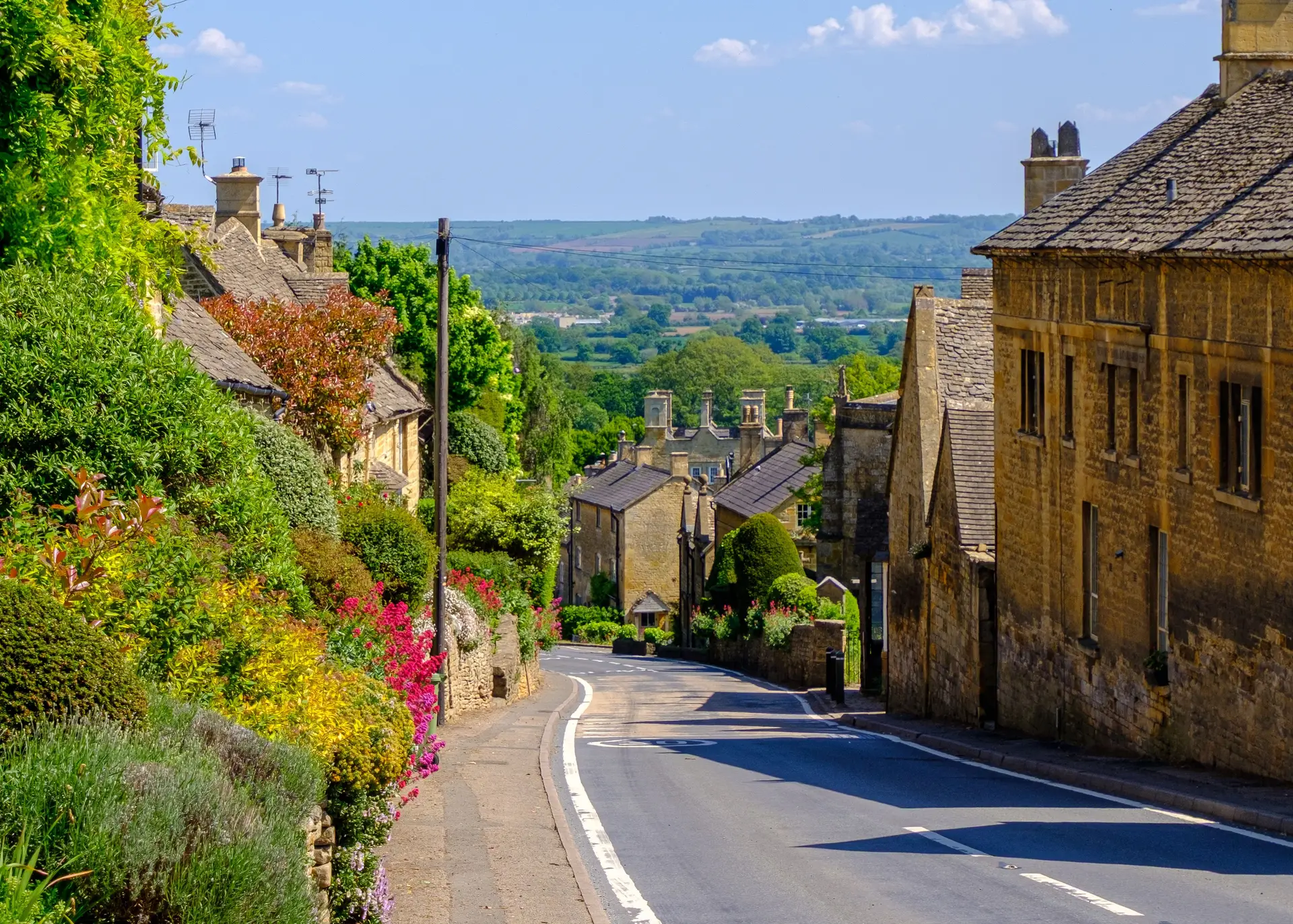 Atmospheric Cotswolds limestone stone cottages along winding village path in England