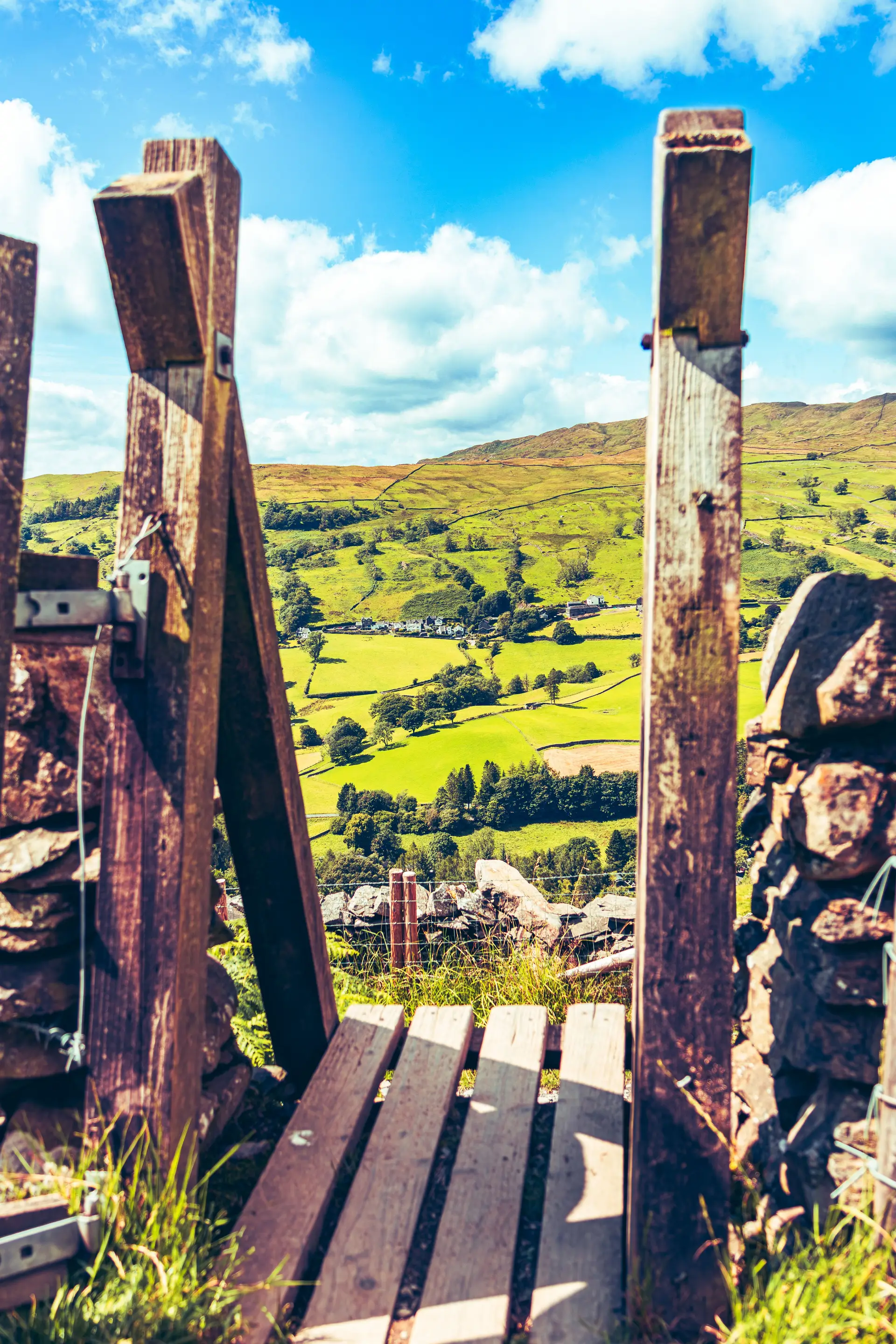 Lush landscape in Troutbeck framed by wooden countryside stile in Cumbria
