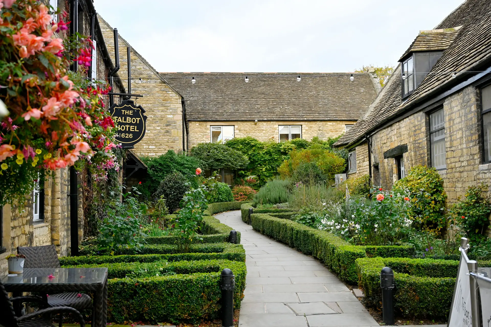 Charming historic English tavern courtyard surrounded by lush country gardens