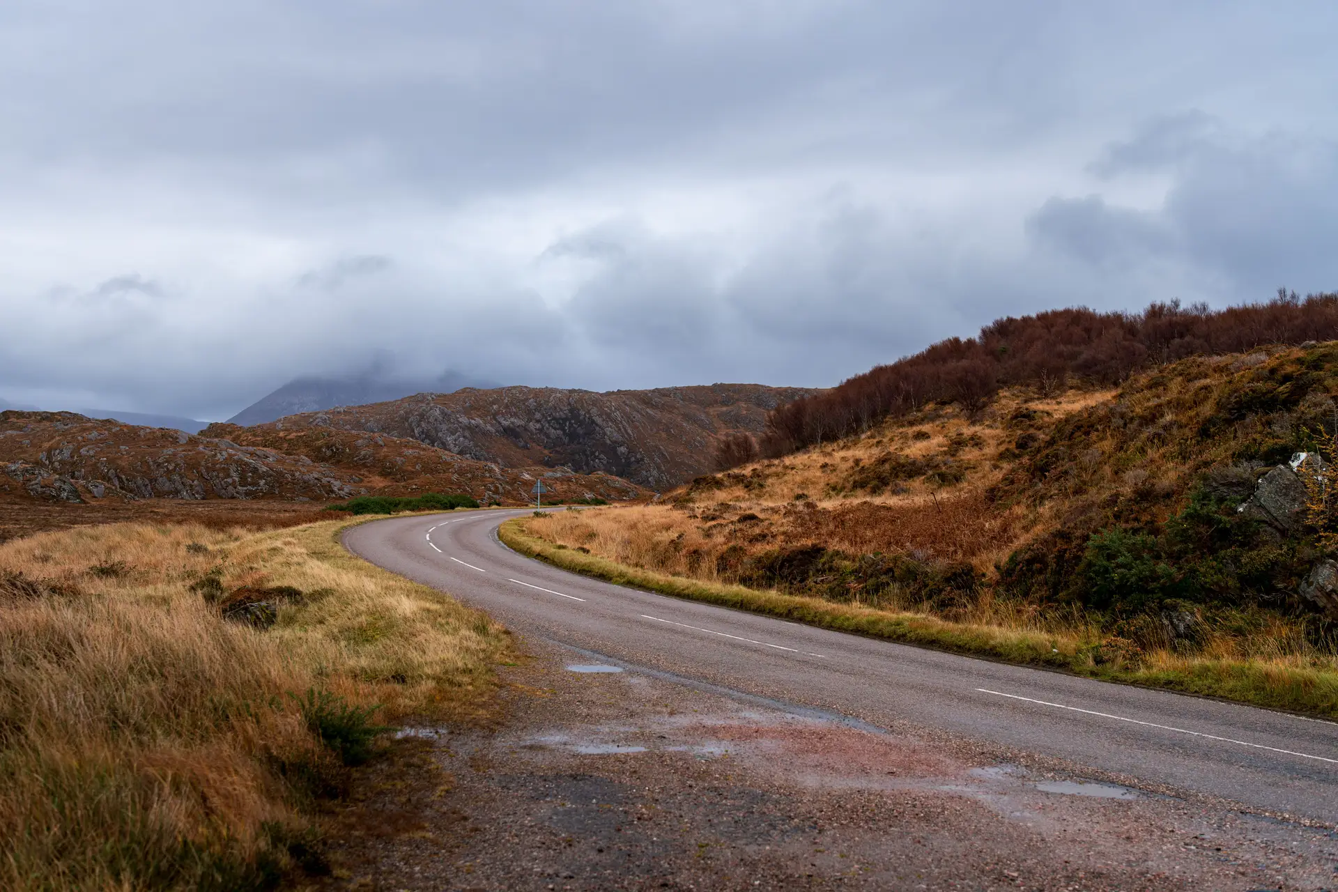 Autumnal hillside road overlooking a quiet loch in Argyll