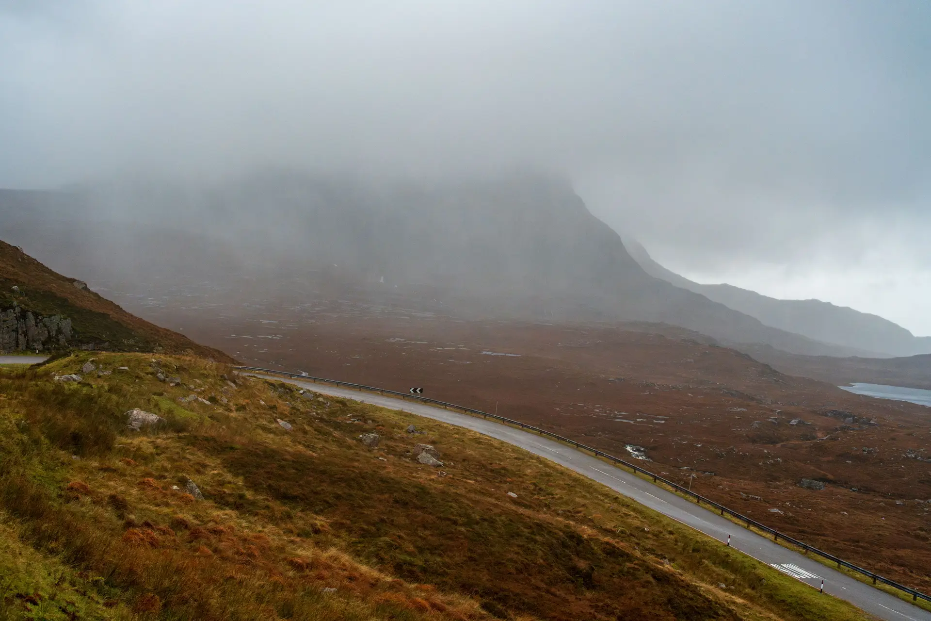 Mountain pass curving through tranquil valley mist