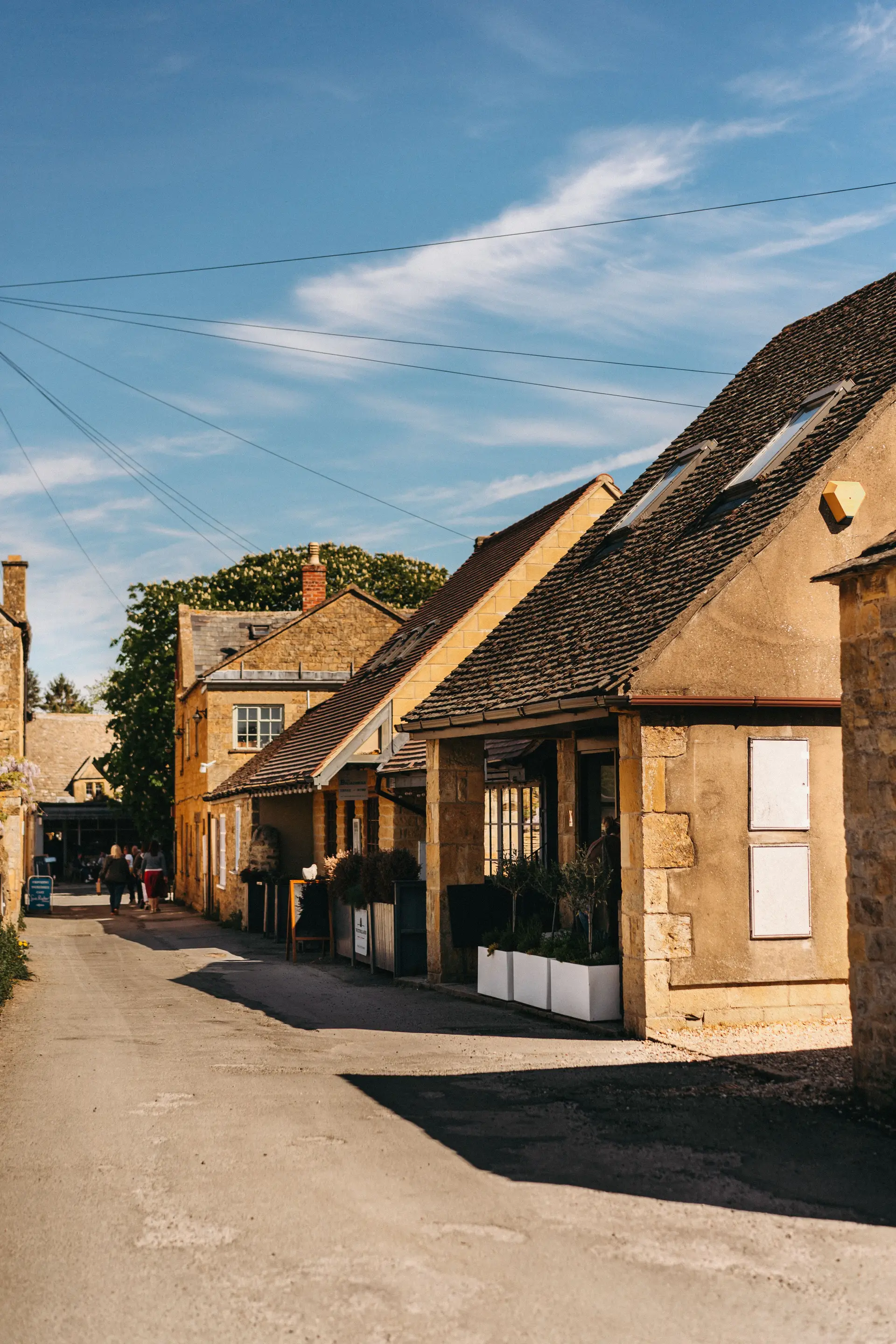 Stone cottages and vibrant floral gardens in an English country lane